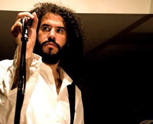 Daniel Bejar Destroyer performing with microphone and white shirt