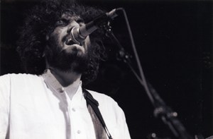 Daniel Bejar of Destroyer singing into microphone black and white