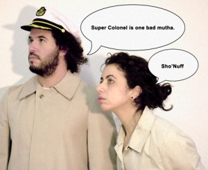 Daniel Bejar Destroyer wearing tan trench coat and captains hat with speech bubbles and woman