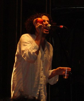 daniel-bejar-destroyer-wearing-white-shirt-singing-into-microphone-while-shaking-orange-1 Daniel Bejar Destroyer wearing white shirt singing into microphone while shaking orange